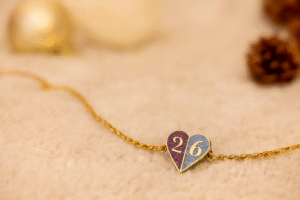 Κολιέ γούρι 2026 από χρωματιστό σμάλτο με glitter και επιχρυσωμένη ατσάλινη αλυσίδα. Ένα μοναδικό γούρι για καλή τύχη και στυλ όλη τη χρονιά!