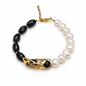 Χειροποίητο βραχιόλι από Ασήμι 925 με πέτρες μαύρου όνυχα, φυσικά μαργαριτάρια και επιχρυσωμένες λεπτομέρειες. Οργανική υφή και γλυπτική ισορροπία.