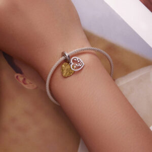 Διπλό charm καρδιά από ασήμι 925 με λευκά ζιργκόν και επιχρυσωμένες λεπτομέρειες. Κομψό δίχρωμο κόσμημα με συμβολισμό αγάπης.