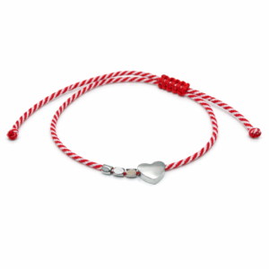 Χειροποίητο μαρτάκι με κόκκινο-λευκό στριφτό κορδόνι, μεταλλική καρδιά και διακοσμητικές λεπτομέρειες. Ιδανικό για δώρο Μαρτίου με ανοιξιάτικη διάθεση.