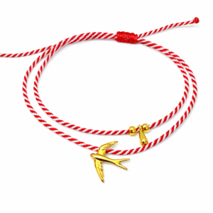 Χειροποίητο διπλό βραχιόλι μαρτάκι με κόκκινο-λευκό κορδόνι, χελιδόνι και διακοσμητικές λεπτομέρειες. Ρυθμιζόμενο, ιδανικό για δώρο Μαρτίου.