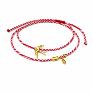 Χειροποίητο διπλό βραχιόλι μαρτάκι με κόκκινο-λευκό κορδόνι, χελιδόνι και διακοσμητικές λεπτομέρειες. Ρυθμιζόμενο, ιδανικό για δώρο Μαρτίου.